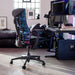 Een Herman Miller X Logitech Embody Gaming Chair in blauw Cyaan als onderdeel van een gamingopstelling.