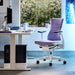 Een Herman Miller X Logitech Embody Gaming Chair in paars Amethist als onderdeel van een gamingopstelling.